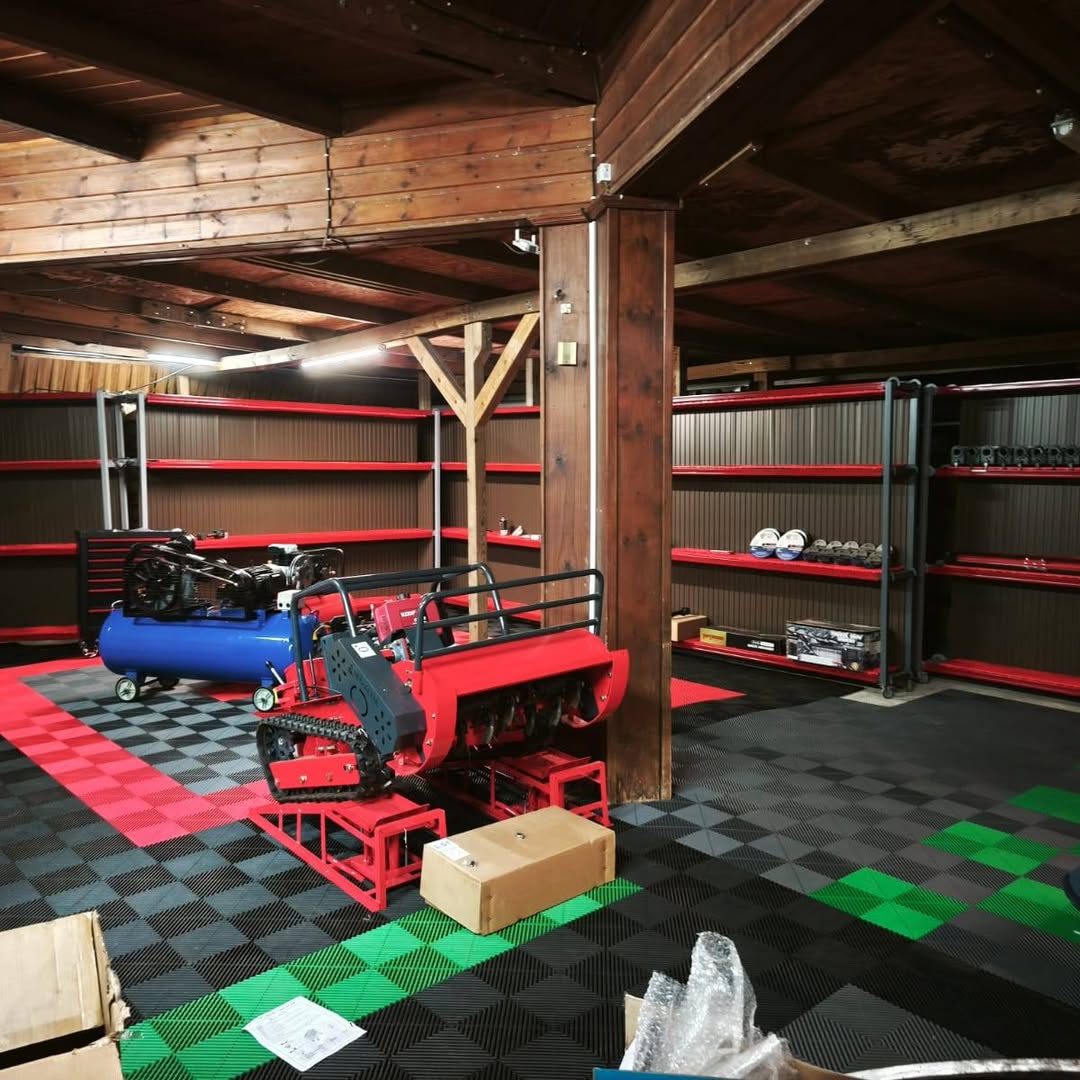 Showroom Kèr'volk : rayonnages rouges, compresseur et robot débroussailleur